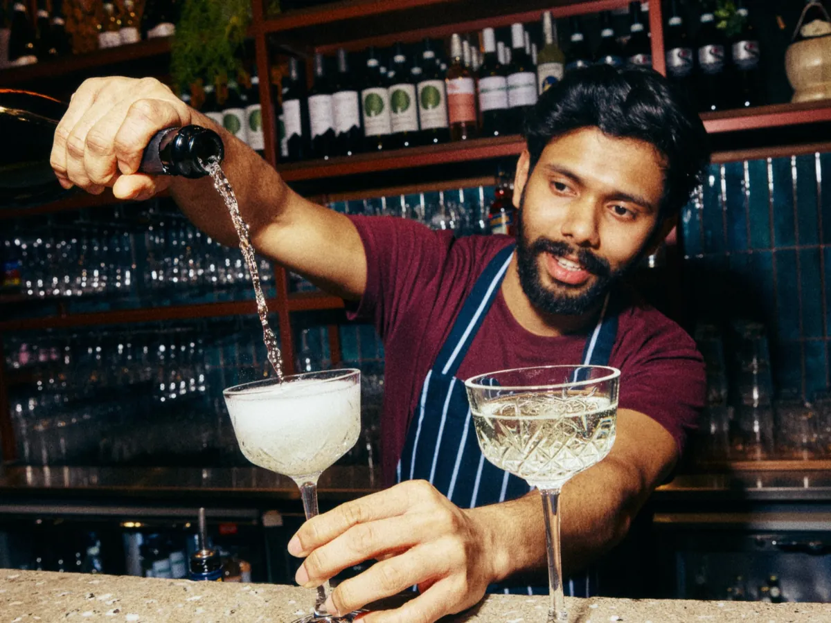 A bartender pouring glasses of prosecco at Zizzi